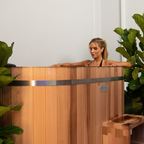 Woman standing in a wooden cedar ice bath with plants around