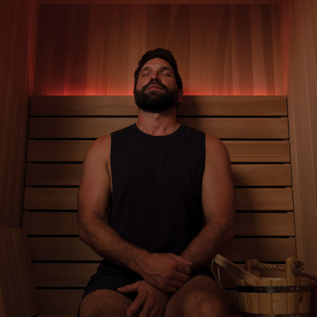 Man sitting in a wooden sauna with eyes closed