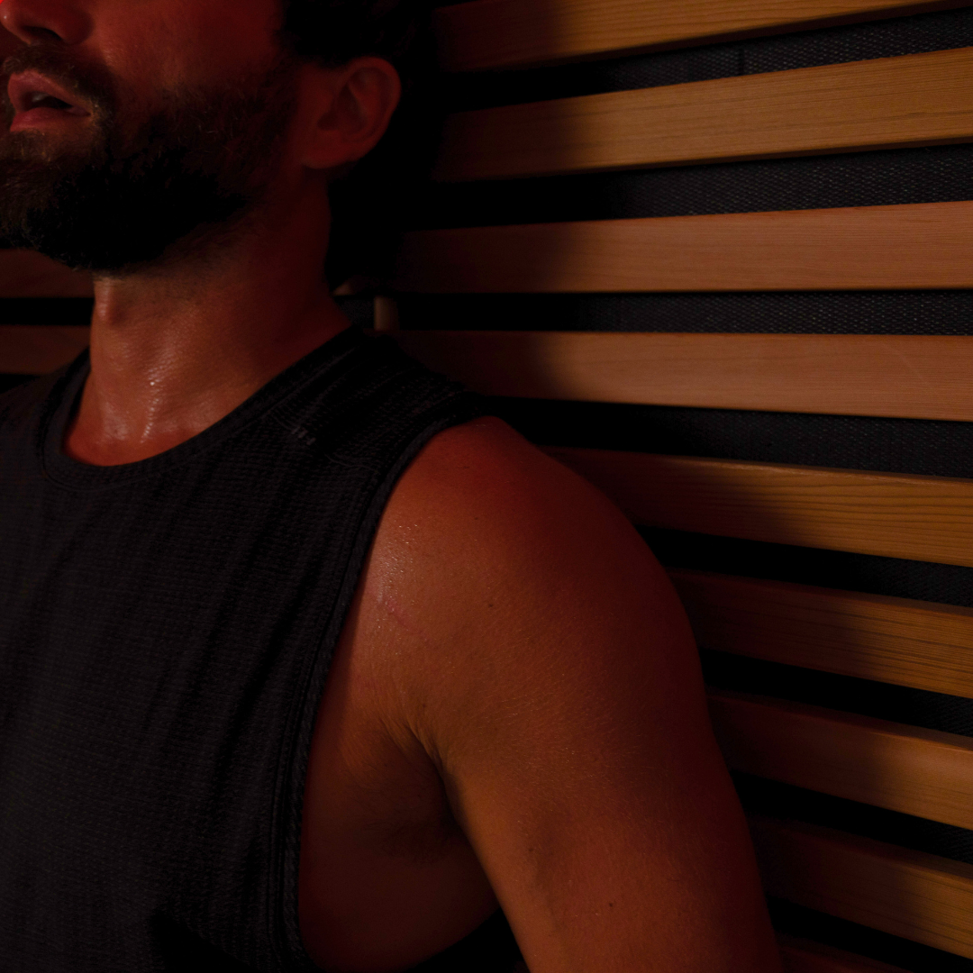 Man with a beard leaning against a wooden wall