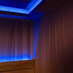Wooden sauna with blue LED lights on the ceiling