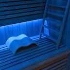 Infrared sauna with wooden bench and ladder, illuminated with blue light.