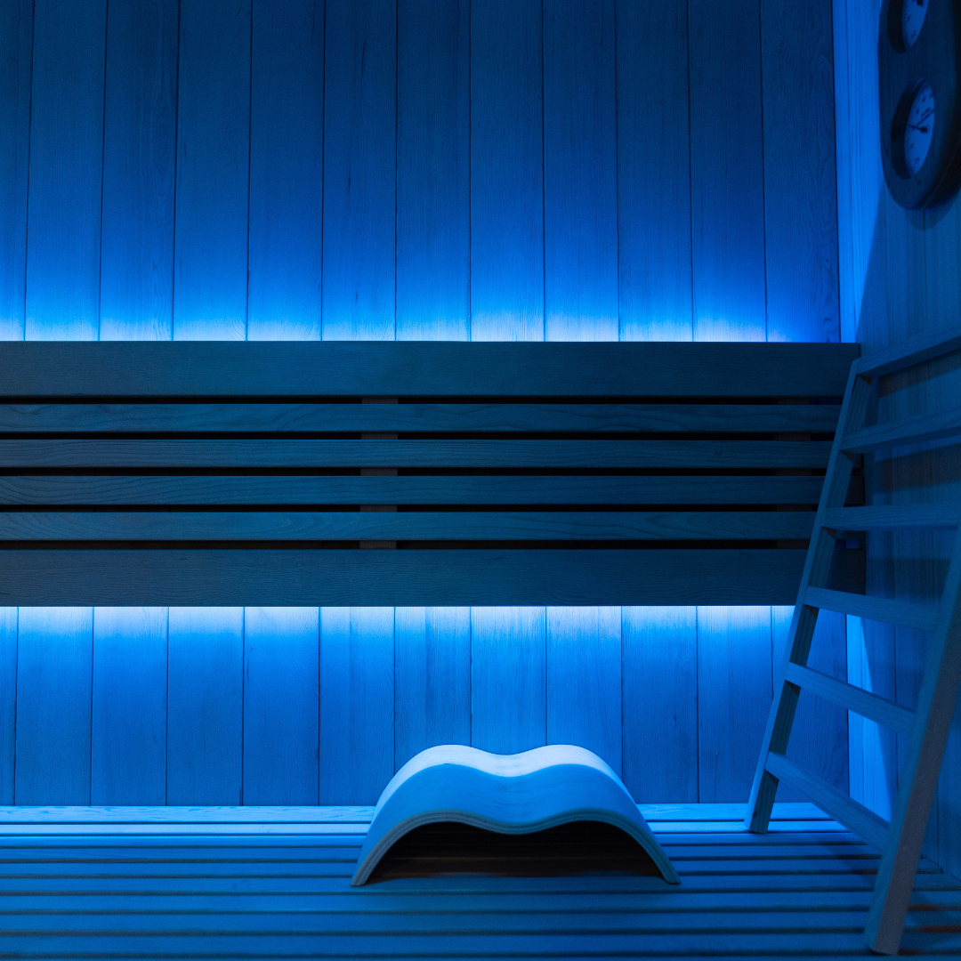 Infrared sauna with blue LED lighting and wooden interior.