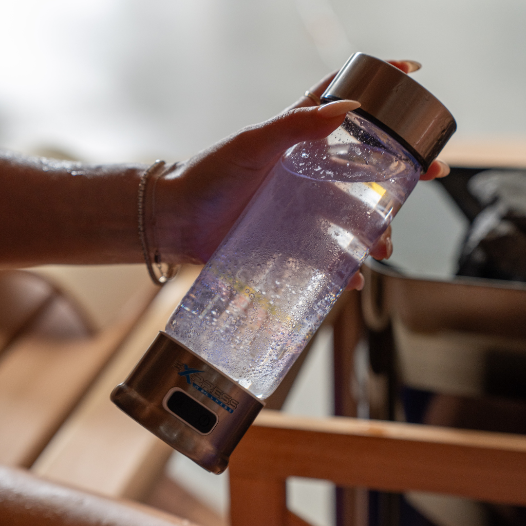 Hand holding a water bottle with a blurred background
