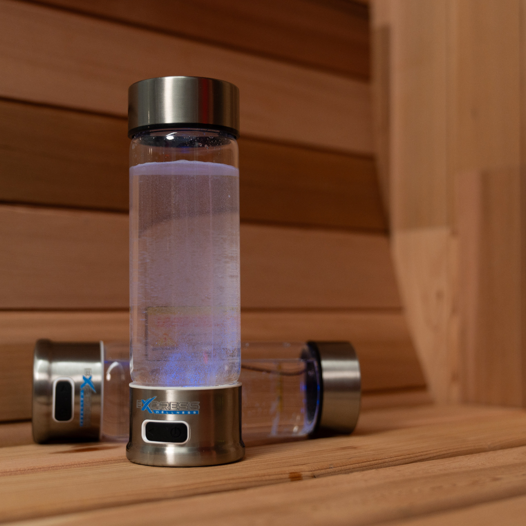 Clear water bottle with metal cap and base on a wooden surface