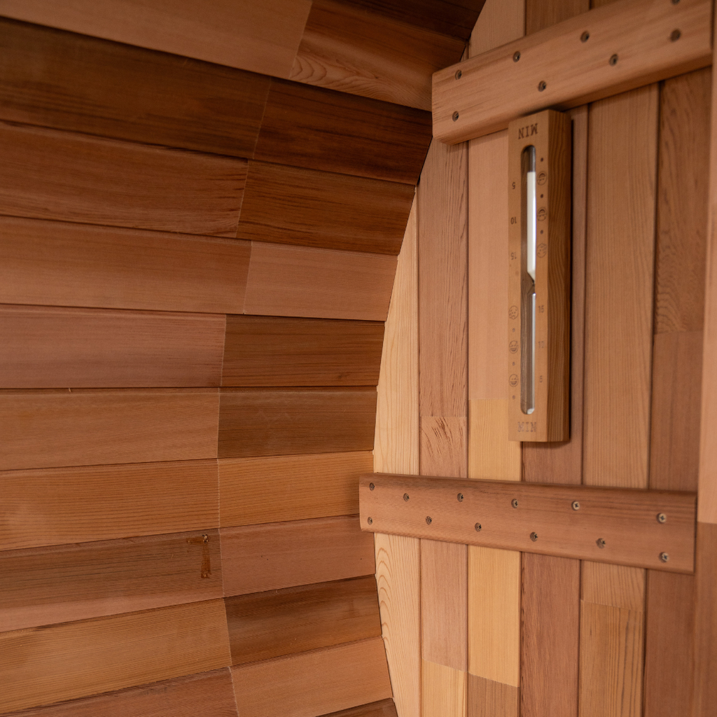 Wooden sauna door with a thermometer on a wooden wall.