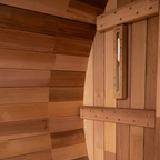 Wooden sauna door with a thermometer on a wooden wall.