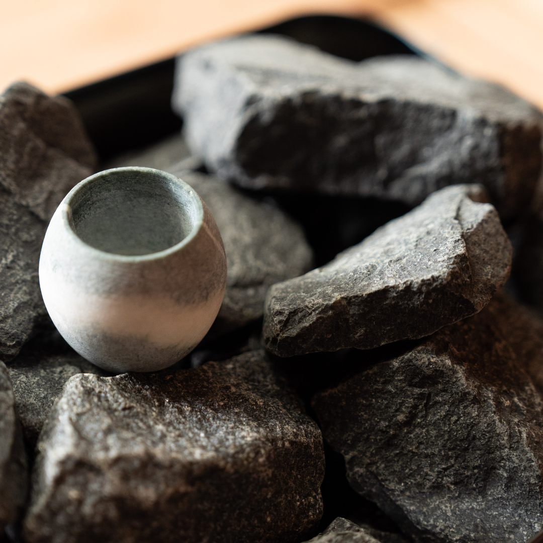 Ceramic cup on a bed of dark stones