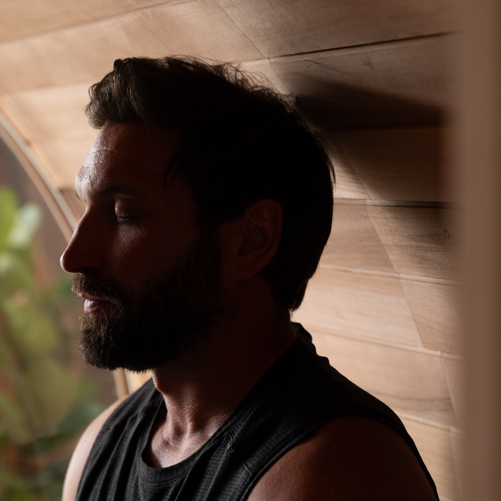 Man with a beard and short hair against a wooden wall